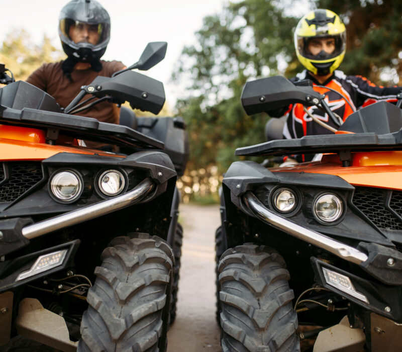 Two riders on quad bikes, front view, closeup