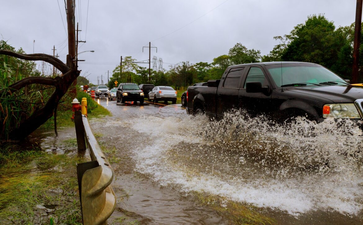 Flooded feeder street splash by a car Heavy rains from hurricane Harvey caused many flooded
